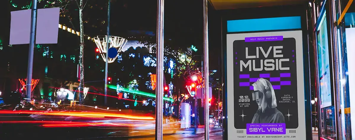Long exposure of roadway with glowing decorations and empty station with illuminated blank advertising banner and glass walls in city in night time